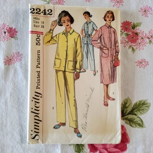 May include: Simplicity Printed Pattern 500, a vintage sewing pattern for a women's pyjama set. The pattern includes three different styles: a yellow pyjama set with a button-up top and trousers, a blue and white striped pyjama set with a button-up top and trousers, and a pink and white gingham dressing gown. The pattern is for size 18, bust 38.