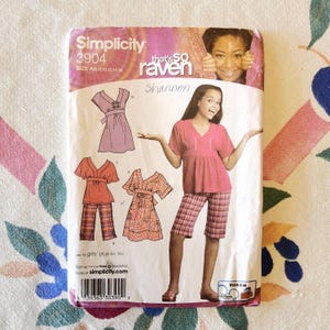 May include: A Simplicity sewing pattern packet featuring a pink and white plaid outfit, a pink top and shorts, and other clothing designs. The packet includes the text "that's so raven" and "Shannon".