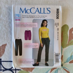 May include: McCall's sewing pattern for beginners, featuring a woman in a yellow top and plaid pants. The pattern includes instructions for a fly front zipper and a side pocket. Size A5 (6-8-10-12-14).