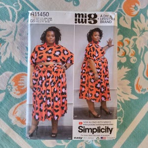 May include: A Simplicity sewing pattern envelope featuring a woman in a two-piece outfit. The orange fabric has a black and purple leopard print. The pattern is size US 26W-34W. The brand is "mig" and the pattern is "easy-to-sew".