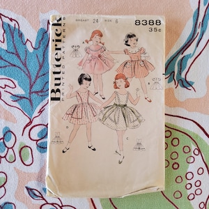 May include: Vintage Butterick sewing pattern featuring illustrations of girls in dresses. The pattern is marked with "BREAST 24 SIZE 6" and the number "8388". The price is listed as "35c". The cover is off-white with a slight yellowing.