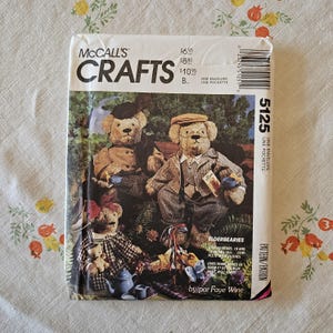 Könnte beinhalten: Ein McCall's Crafts Schnittmusterumschlag 5125 mit einer Illustration von drei bekleideten Teddybären. Der Text umfasst 'McCall's Crafts', '5125', 'Elderbearies', 'Stoffbären, 48 cm und 38 cm groß... komplett mit Kleidung' von Faye Wine.