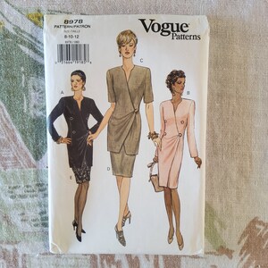 Może przedstawiać: Wzór szycia Vogue Patterns numer 8978 dla rozmiarów 8-10-12. Wzór zawiera trzy różne projekty sukienek: czarną sukienkę z zapięciem na guziki, zieloną sukienkę z zapięciem na zakładkę i różową sukienkę z zapięciem na guziki.