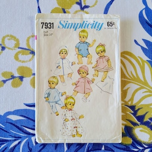 May include: Vintage Simplicity sewing pattern 7931 for a 35.5 cm doll. The pattern features illustrations of dolls in various outfits, including a coat, dress, and pajamas. The pattern is printed on a cream-colored paper with blue text.