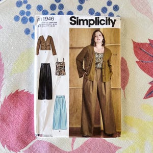 May include: Simplicity sewing pattern R11946 featuring a woman wearing a brown outfit. The pattern includes a jacket, pants, and a camisole. The pattern is designed for sizes 20W-28W. The pattern is printed in the USA.