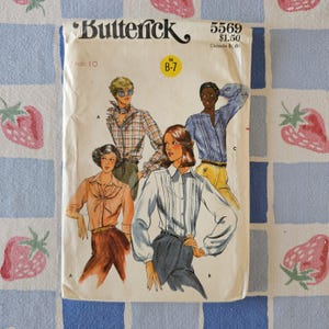 May include: A Butterick 5569 sewing pattern envelope featuring illustrations of four different shirt styles. The cover displays the brand name, the pattern number 5569, size 10, and price information. The illustrations show various long-sleeved shirts.