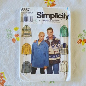 May include: A Simplicity sewing pattern envelope, number 8857, for pullover tops in sizes XS, S, and M. The white paper envelope features illustrations of five different pullover styles, including solid colors and patterned designs with deer and geometric motifs.