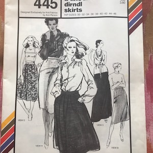 Può includere: Modello di cucito vintage per gonne dritte, a trapezio e dirndl. Il modello, etichettato "445" da Stretch & Sew, presenta illustrazioni di vari stili di gonne. La copertina include testo e un prezzo di vendita consigliato.