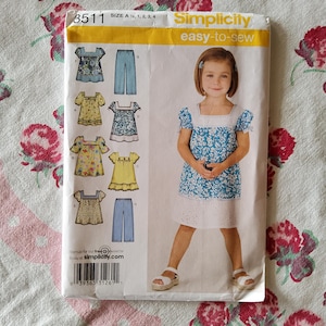 Puede incluir: Un patrón de costura para un vestido de niña con una variedad de estampados florales. El patrón es de Simplicity y es fácil de coser. El número del patrón es 3511.