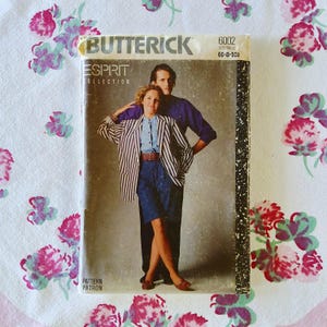 May include: A vintage Butterick sewing pattern envelope featuring a couple in 1980s attire. The woman wears a striped blazer, denim skirt, and a denim shirt. The man wears a purple shirt. The envelope reads "ESPRIT COLLECTION".