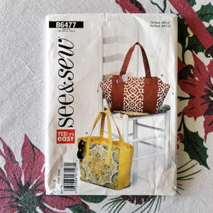 May include: A sewing pattern package showing two tote bags. One bag is brown with a white geometric pattern, and the other is yellow with a floral design. The package has the text "see & sew" and "YES! It's easy".
