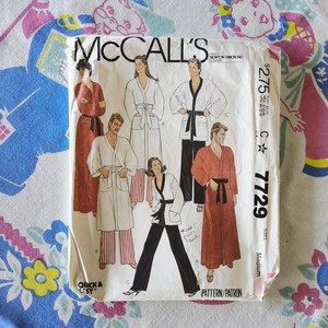May include: A McCall's sewing pattern envelope 7729 for robes and pajamas. The front shows illustrations of six individuals wearing various robe and pant styles in red, white, and black. The text includes the brand name, pattern number 7729, and size Medium.