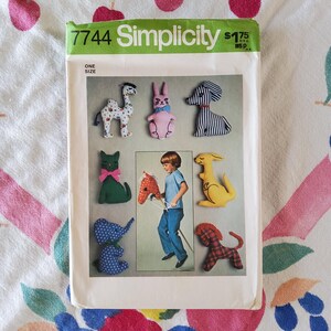 May include: Simplicity sewing pattern 7744 featuring stuffed animal designs. The pattern includes instructions for a camel, rabbit, dog, cat, kangaroo, elephant, and a horse on a stick. The pattern is one size.