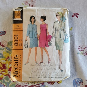May include: Vintage McCall's sewing pattern for a dress and jacket ensemble. The pattern is for size 12, bust 32. The pattern is printed on a yellow background with a white border. The pattern features three women wearing the dress and jacket ensemble. The text on the pattern reads "McCall's Printed Pattern 8801 Size 12 Bust 32 Dressmaker Tested 75¢ 85¢ in Canada Misses' Dress and Jacket Ensemble".