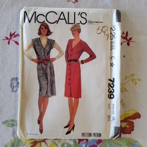 May include: McCall's sewing pattern number 7239 for a dress, size 10, bust 32 1/2 inches. The pattern includes two dress styles, one with a red button-up dress and the other with a gray button-up dress with a vest.