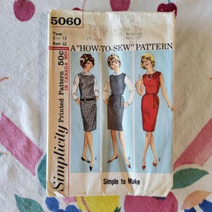 Könnte beinhalten: Vintage Simplicity Schnittmuster, Größe 12, Brustumfang 81 cm. Das Muster zeigt drei Kleiderdesigns. Das Cover trägt den Text "A How-To-Sew Pattern" und "Simple to Make". Das Muster ist in Kanada für 60c gedruckt.