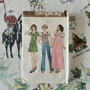 May include: A Simplicity 6673 sewing pattern envelope featuring illustrations of three outfits: a green floral mini dress, a floral blouse with blue jeans, and a long pink dress. The envelope displays size 11/12 and bust 32 inches.