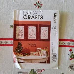 Peut inclure: Un patron de couture McCall's Crafts pour trois projets de broderie sur le thème de Noël. Le patron est intitulé "Pear Louise Designs" et comprend un sapin de Noël, le Père Noël et un bonhomme de neige. Le numéro du patron est M6001.