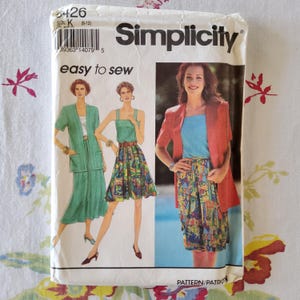 Può includere: Modello di cucito Simplicity numero 6426 per le taglie 8-12. Il modello include istruzioni per realizzare una gonna e una giacca. La modella indossa una gonna verde con una stampa colorata e una giacca rossa. Il testo "easy to sew" è stampato sul modello.