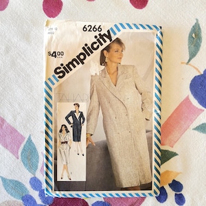 May include: Simplicity sewing pattern 6266 for a double-breasted coat dress. The pattern features a woman in a light beige coat dress. The pattern includes the text "Simplicity" and "Tahar". The price is $4.00.