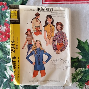 May include: A vintage McCall's sewing pattern for a misses' and young junior/teen blouse. The pattern includes four different styles of blouses, with long and short sleeves, and a variety of necklines. The pattern is labelled "Easy" and includes instructions on how to set in a sleeve.