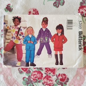 May include: A sewing pattern for children's clothing, featuring four girls wearing different outfits. The pattern is from Butterick and is for sizes 6-7/8. The pattern includes a red, blue, purple, and yellow outfit.