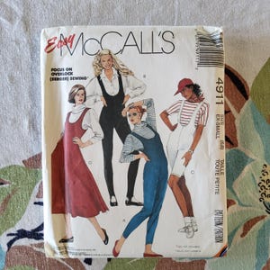 May include: An Easy McCall's sewing pattern envelope featuring illustrations of women in various overalls and dresses. The envelope is white with the text "Easy McCall's" and "Focus on Overlock (Serger) Sewing". The size is EX-SMALL.