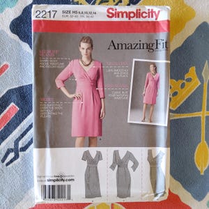 Puede incluir: Un patrón de costura para un vestido con escote cruzado y una falda que se ajusta suavemente al cuerpo. El patrón es de Simplicity y forma parte de la colección Amazing Fit. El patrón es para las tallas H5 6, 8, 10, 12, 14, EUR 32-40, FR 34-42.