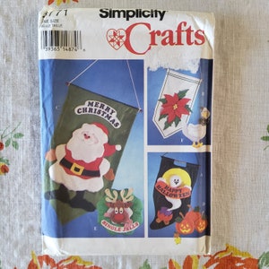 Könnte beinhalten: Ein Simplicity Crafts-Muster zum Nähen von vier verschiedenen Weihnachtsbannern. Die Banner zeigen einen Weihnachtsmann, ein Rentier, ein Gespenst und einen Weihnachtsstern. Das Muster enthält Anleitungen zum Nähen jedes Banners sowie Vorlagen zum Ausschneiden der Formen.