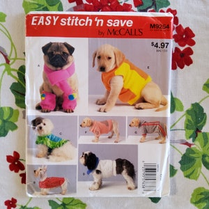 May include: A sewing pattern for dog clothes, featuring a variety of dog breeds wearing different outfits. The pattern is titled "Easy Stitch 'n Save" by McCall's and has the number M9254. The price is $4.97.