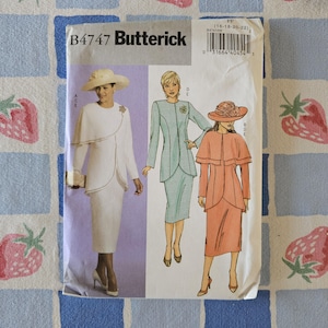May include: A Butterick B4747 sewing pattern envelope featuring illustrations of three outfits: a white dress with a cape, a light blue jacket and skirt set, and a peach-colored dress with a cape. Each outfit includes a matching hat and brooch.