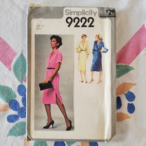 May include: Simplicity sewing pattern number 9222 for a dress. The pattern is for size 12 miss. The pattern shows a pink dress with a white collar and a blue dress with a white collar.