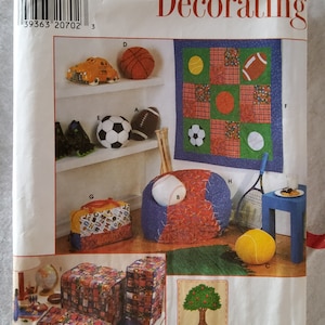 May include: A Simplicity Home Decorating sewing pattern featuring a variety of sports-themed home decor projects. The pattern includes instructions for making a quilt, beanbag chair, storage bins, and other items. The pattern is illustrated with colorful drawings of the finished projects.