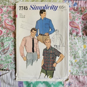 May include: A Simplicity 7745 sewing pattern envelope featuring illustrations of three shirts: a solid blue long-sleeve shirt, a red and white striped long-sleeve shirt with a black tie, and a red, green, and blue plaid short-sleeve shirt.