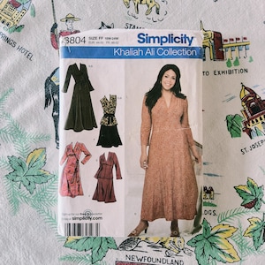 May include: A Simplicity sewing pattern envelope, number 3804, from the Khaliah Ali Collection, size FF 18W-24W. The front displays illustrations of various dress and skirt styles, alongside a photograph of a model wearing a long, patterned dress.