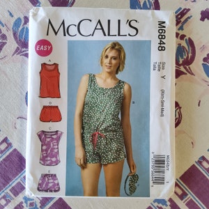 May include: A sewing pattern for a sleeveless top and shorts set. The pattern is for sizes X-Small, Small, and Medium. The pattern is labeled "Easy" and has a green and white polka dot print.