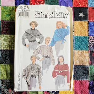 May include: A Simplicity sewing pattern envelope, number 8806, size KK (8-14). The front displays illustrations of five different long-sleeved button-down shirts with various collars, patterns, and tie-front details, worn with belts and skirts.