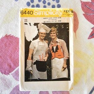 Puede incluir: Un paquete de patrones de costura Simplicity vintage, con dos hombres con delantales y gorros de chef. El paquete está etiquetado "6440" e incluye texto sobre el centro de telas y el tamaño. La imagen muestra un estilo retro con un enfoque en la ropa de cocina.