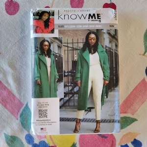 May include: A sewing pattern package featuring a woman in a green coat and cream-colored pants. The package includes the text "KNOW ME by mimiG" and "BEAUTE J'ADORE". The size is W3 (30W-32W-34W-36W-38W).