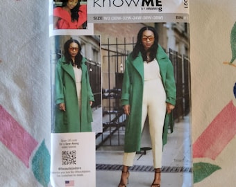 Può includere: Un modello di cucito con una donna che indossa un cappotto verde e pantaloni color crema. La confezione include il testo "KNOW ME by mimiG" e "BEAUTE J'ADORE". La taglia è W3 (30W-32W-34W-36W-38W).