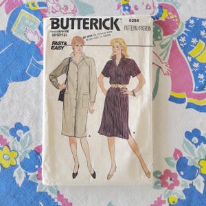 May include: A Butterick 6284 sewing pattern envelope featuring two dress designs. One is a long-sleeved beige button-down dress with pockets, and the other is a short-sleeved purple pinstriped button-down dress with a belt. Size range 8-10-12.