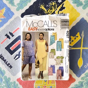May include: A McCall's sewing pattern packet showcasing women's clothing designs. The packet displays the text "McCall's EASY ENDLESS options" and includes various garment options, such as tops, trousers, and shorts. The pattern number is 4097.
