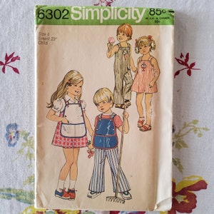 May include: Simplicity sewing pattern number 6302 for children's clothing. The pattern includes three designs: a girl wearing a gingham dress and an apron, a boy wearing overalls, and a girl wearing a dress with a bib. The pattern is for size 4, with a 23 inch chest.