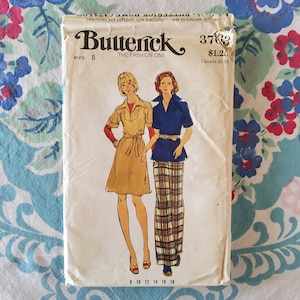 Könnte beinhalten: Vintage-Nähmuster-Umschlag für ein Kleid und einen Rock. Das Muster ist von Butterick, Musternummer 3783, Größe 8. Der Umschlag zeigt Illustrationen von zwei Frauen, die die Kleidungsstücke tragen. Das Kleid ist beige mit einem braunen Gürtel und der Rock ist kariert mit einem blauen Oberteil.