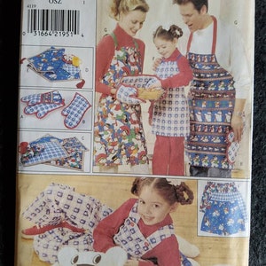 May include: A sewing pattern for a family of three, featuring a blue and white checked apron with a snowman design. The pattern includes a matching oven mitt and a pillow. The pattern number is 4119.