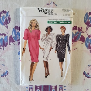 Peut inclure: Patron de couture Vogue Patterns pour une robe, mettant en scène trois femmes portant différents styles de robes. Le patron est pour les tailles 8-10-12 et est étiqueté "Très facile/Very Easy".