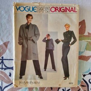 Puede incluir: Patrón de costura vintage Vogue Paris Original con diseños de Yves Saint Laurent. La portada muestra ilustraciones de moda femenina, incluyendo un abrigo largo, chaqueta y pantalones. El número de patrón es 2272.