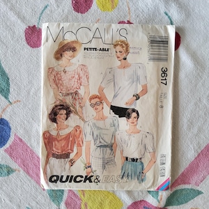 May include: A vintage McCall's sewing pattern, featuring illustrations of women's tops. The pattern is labeled "PETITE-ABLE" and "QUICK & EASY." The cover art showcases various blouse designs, with the size listed as 8. The pattern includes the number 3617.