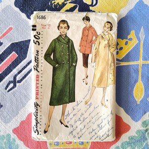 May include: Vintage Simplicity pattern 1686 featuring illustrations of women's coats. The pattern includes a green double-breasted coat, a rust-colored coat, and a light yellow coat. The pattern is marked size 12, bust 32.