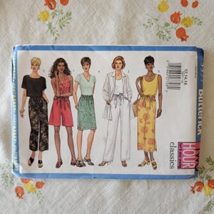 May include: A Butterick Classics sewing pattern envelope for sizes 12, 14, and 16. The front features illustrations of five outfits including a black top with patterned pants, a red romper, a green skirt, white trousers with a jacket, and a yellow dress.